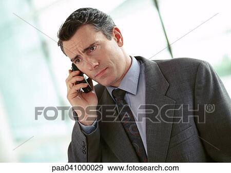 Businessman holding cell phone, portrait View Large Photo Image Stock Photo - Businessman holding cell phone, portrait. Fotosearch