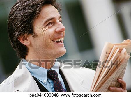 Businessman holding newspaper, smiling, portrait View Large Photo Image Stock Photo - Businessman holding newspaper, smiling, portrait. Fotosearch