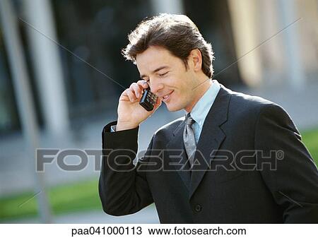 Businessman using cell phone outside View Large Photo Image Stock Image - Businessman using cell phone outside. Fotosearch