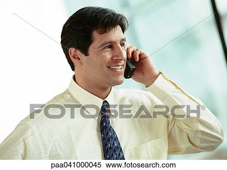 Stock Photography - Businessman using cell phone, portrait. Fotosearch