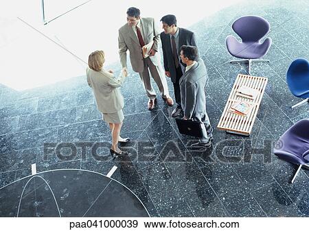Four business people gathered in hall, elevated view View Large Photo Image Stock Photo - Four business people gathered in hall, elevated view. Fotosearch