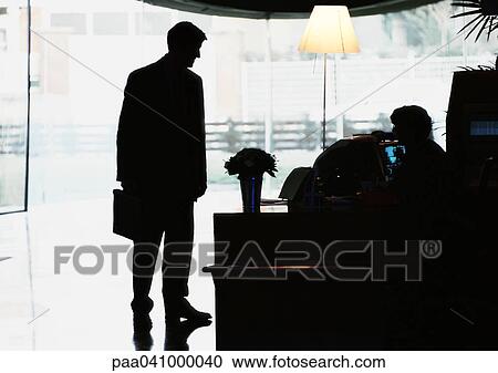 Silhouette of businessman standing by desk View Large Photo Image Stock Image - Silhouette of businessman standing by desk. Fotosearch