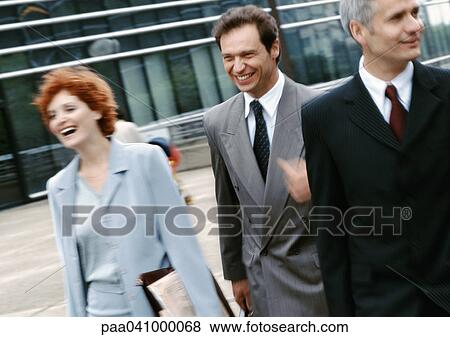 Three business people walking outside View Large Photo Image Stock Photo - Three business people walking outside. Fotosearch
