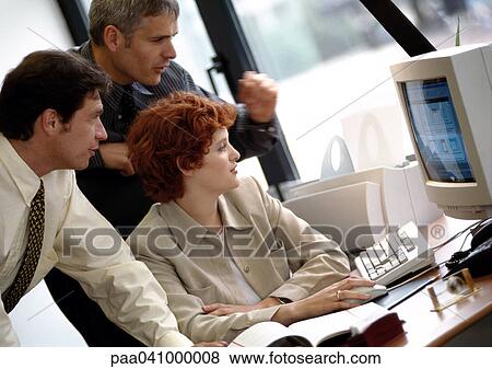 Two businessmen and a businesswoman looking at computer screen View Large Photo Image Stock Photo - Two businessmen and a businesswoman looking at computer screen. Fotosearch