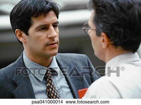 Two businessmen standing face to face View Large Photo Image Picture - Two businessmen standing face to face. Fotosearch