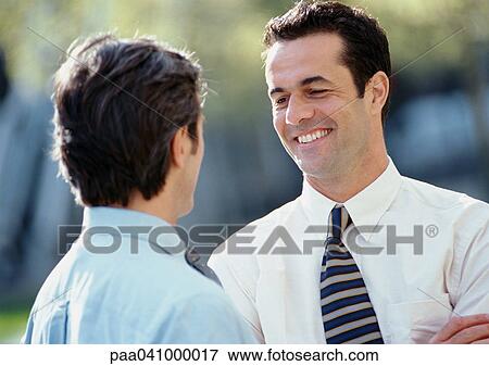 Two businessmen standing face to face, outside View Large Photo Image Stock Photo - Two businessmen standing face to face, outside. Fotosearch
