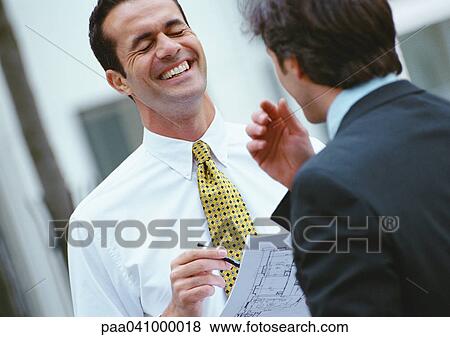 Two businessmen standing face to face View Large Photo Image Stock Photo - Two businessmen standing face to face. Fotosearch