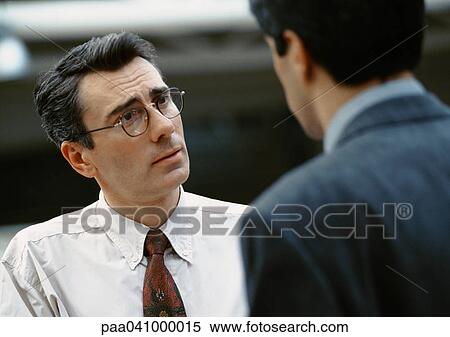 Stock Photography - Two businessmen standing face to face. Fotosearch