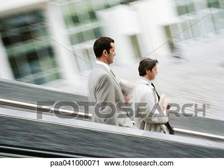 Two businessmen walking down stairs, blurred View Large Photo Image Stock Image - Two businessmen walking down stairs, blurred. Fotosearch