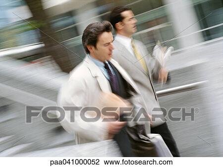 Two businessmen walking outside, blurred motion View Large Photo Image Stock Image - Two businessmen walking outside, blurred motion. Fotosearch