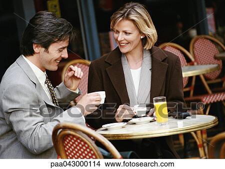 Businessman and businesswoman having coffee at cafe terrace View Large Photo Image Picture - Businessman and businesswoman having coffee at cafe terrace. Fotosearch