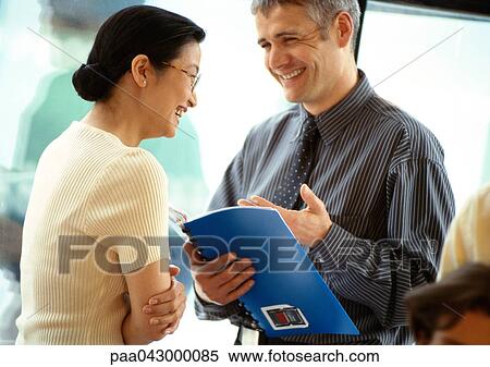 Businessman and businesswoman laughing face to face, businessman holding document View Large Photo Image Stock Photography - Businessman and businesswoman laughing face to face, businessman holding document. Fotosearch