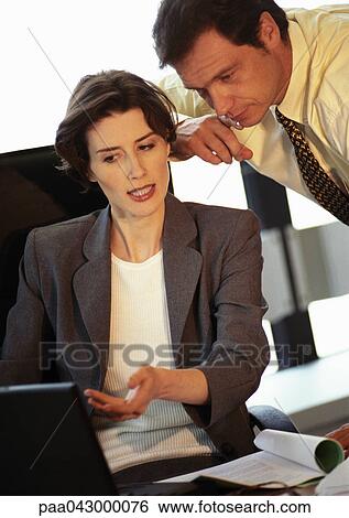 Businessman and businesswoman looking at laptop computer View Large Photo Image Stock Photograph - Businessman and businesswoman looking at laptop computer. Fotosearch