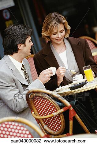 Businessman and businesswoman sitting at cafe terrace View Large Photo Image Stock Image - Businessman and businesswoman sitting at cafe terrace. Fotosearch