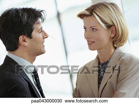 Businessman and businesswoman standing face to face, close-up View Large Photo Image Stock Image - Businessman and businesswoman standing face to face, close-up. Fotosearch