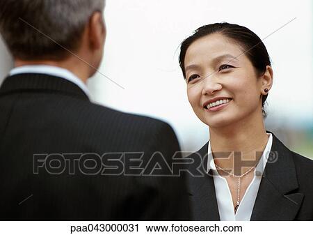 Businessman and businesswoman standing face to face View Large Photo Image Stock Image - Businessman and businesswoman standing face to face. Fotosearch