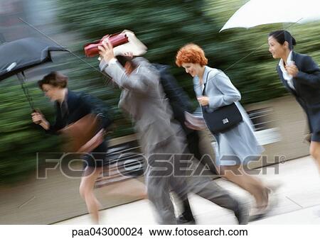 Businesspeople running in rain, blurred View Large Photo Image Picture - Businesspeople running in rain, blurred. Fotosearch