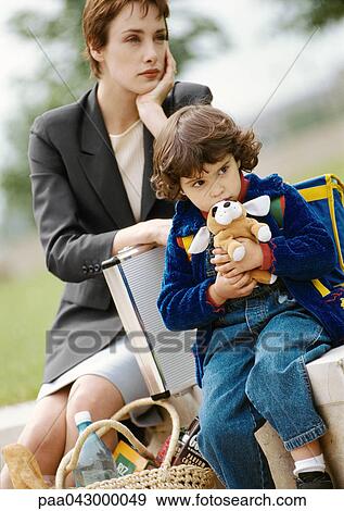 Businesswoman and child sitting, child hugging stuffed dog View Large Photo Image Stock Photo - Businesswoman and child sitting, child hugging stuffed dog. Fotosearch