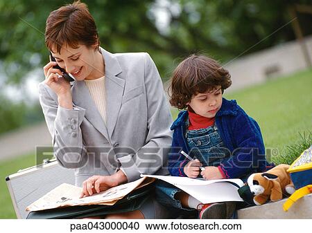 Businesswoman and child sitting outside together, woman using cell phone View Large Photo Image Stock Image - Businesswoman and child sitting outside together, woman using cell phone. Fotosearch