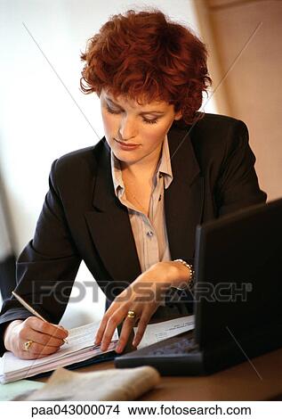 Businesswoman at desk, writing View Large Photo Image Picture - Businesswoman at desk, writing. Fotosearch