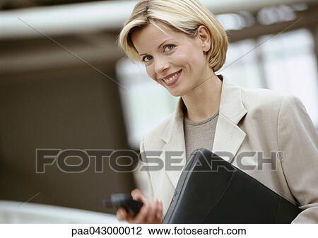 Businesswoman holding laptop computer, smiling at camera, portrait View Large Photo Image Stock Image - Businesswoman holding laptop computer, smiling at camera, portrait. Fotosearch