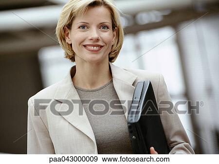 Businesswoman holding laptop computer, smiling at camera, portrait View Large Photo Image Stock Photo - Businesswoman holding laptop computer, smiling at camera, portrait. Fotosearch