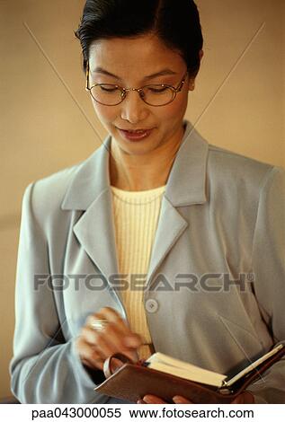 Stock Photography - Businesswoman looking down at agenda, portrait. Fotosearch