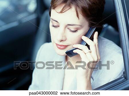 Businesswoman sitting in car looking down, using cell phone View Large Photo Image Stock Image - Businesswoman sitting in car looking down, using cell phone. Fotosearch