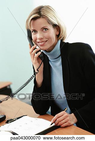 Businesswoman using telephone, smiling at camera, portrait View Large Photo Image Stock Image - Businesswoman using telephone, smiling at camera, portrait. Fotosearch