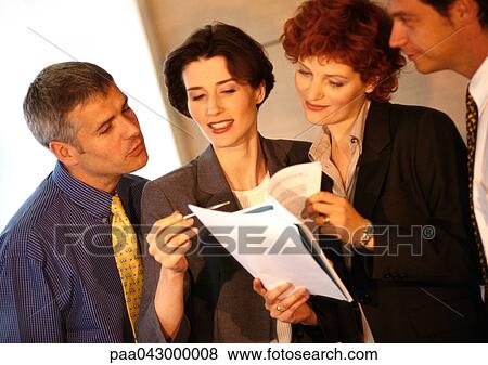 Four business people examining documents View Large Photo Image Stock Photo - Four business people examining documents. Fotosearch