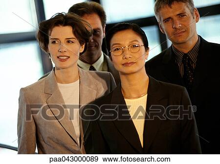 Stock Photo - Four business people grouped together. Fotosearch