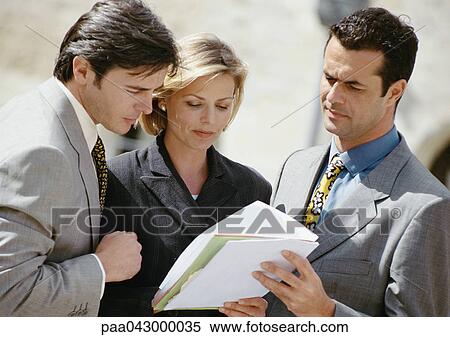 Two businessmen and a woman examining document View Large Photo Image Stock Photography - Two businessmen and a woman examining document. Fotosearch