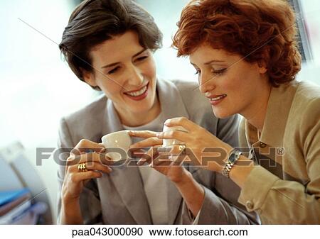 Two businesswomen side by side, holding coffee cups View Large Photo Image Stock Image - Two businesswomen side by side, holding coffee cups. Fotosearch