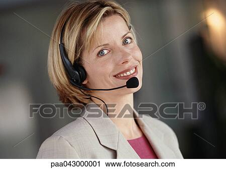 Woman wearing headset, smiling at camera, portrait View Large Photo Image Stock Image - Woman wearing headset, smiling at camera, portrait. Fotosearch