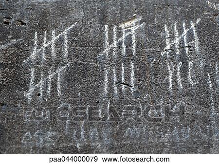 Stock Photo - Chalk marks measuring time on wall, close-up. Fotosearch