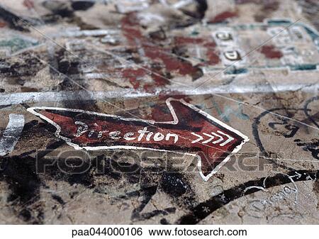 Stock Photograph - Graffiti with "direction" text written inside arrow, close-up. Fotosearch