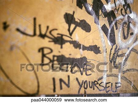 Stock Photo - Just believe in yourself written text and graffiti on wall, close-up. Fotosearch
