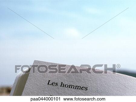 Stock Image - Men text in French printed on page of book, close-up. Fotosearch