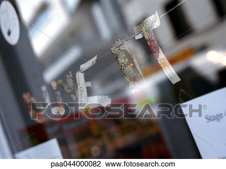 Stock Image - Open text in French, cut out letters attached to string in shop window, close-up. Fotosearch
