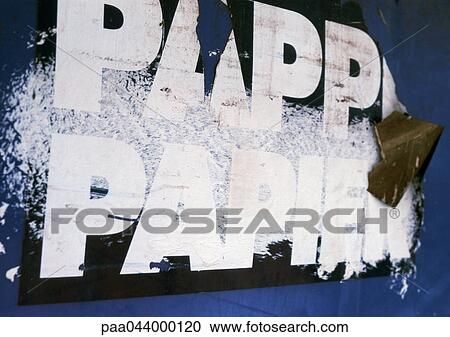 Stock Image - Paper text in French printed on torn poster, close-up. Fotosearch