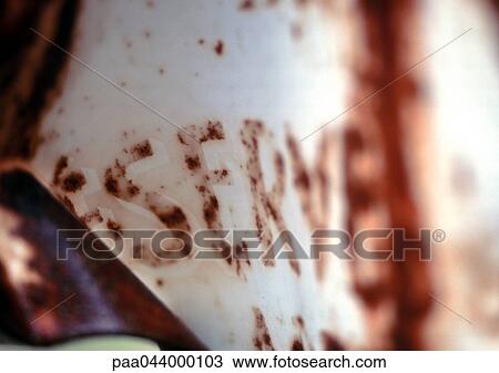 Stock Image - Reserved text in French, partially obscured, on rusted sign, close-up. Fotosearch
