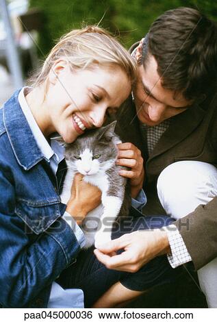 Man and woman holding cat, close-up View Large Photo Image Stock Photograph - Man and woman holding cat, close-up. Fotosearch
