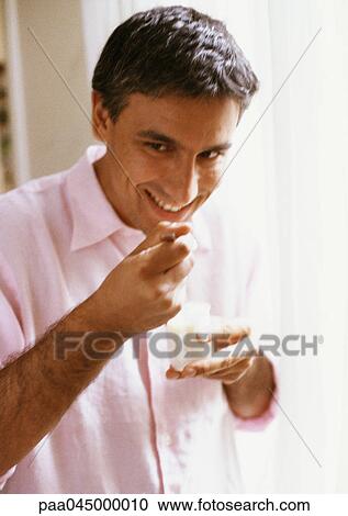 Man eating yogurt, portrait, blurred View Large Photo Image Stock Image - Man eating yogurt, portrait, blurred. Fotosearch
