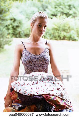 Stock Photo - Woman carrying laundry, waist up. Fotosearch