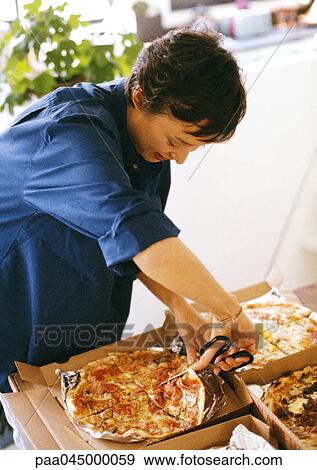 Woman cutting slices of pizza with scissors, waist up View Large Photo Image Stock Photo - Woman cutting slices of pizza with scissors, waist up. Fotosearch