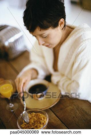 Woman having breakfast at table, looking down, high angle view View Large Photo Image Stock Photo - Woman having breakfast at table, looking down, high angle view. Fotosearch
