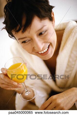 Woman holding glass of juice, smiling, high angle view, close-up View Large Photo Image Stock Photography - Woman holding glass of juice, smiling, high angle view, close-up. Fotosearch