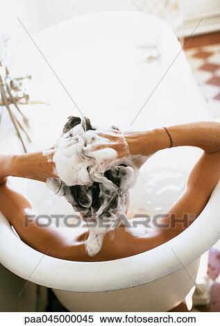 Woman in bathtub, shampooing hair, rear view View Large Photo Image Stock Photography - Woman in bathtub, shampooing hair, rear view. Fotosearch