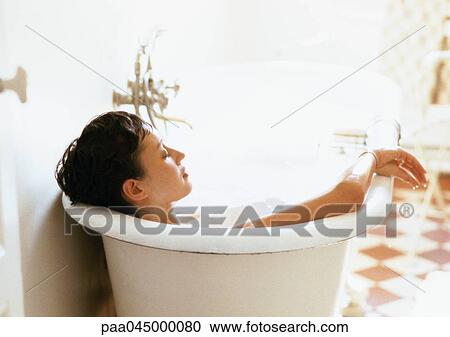 Stock Image - Woman taking bath, rear view, close-up. Fotosearch
