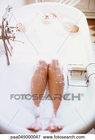 Stock Photo - Woman taking bubble bath, high angle view, blurred. Fotosearch